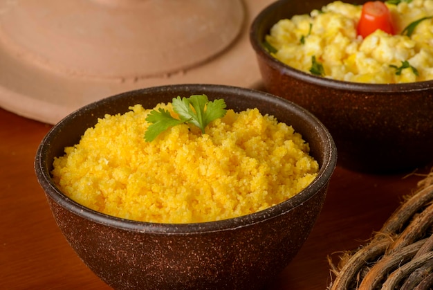 Alimentos do Nordeste do Brasil. Cuscuz de milho com ovo em uma tigela de barro.