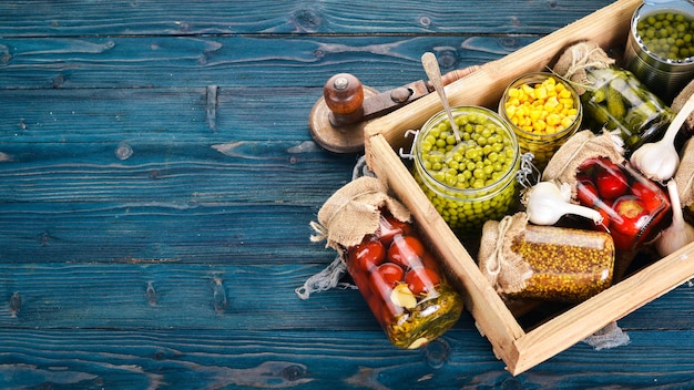 Alimentos em conserva em latas. estoques de alimentos. vista do topo. em um fundo de madeira. copie o espaço.