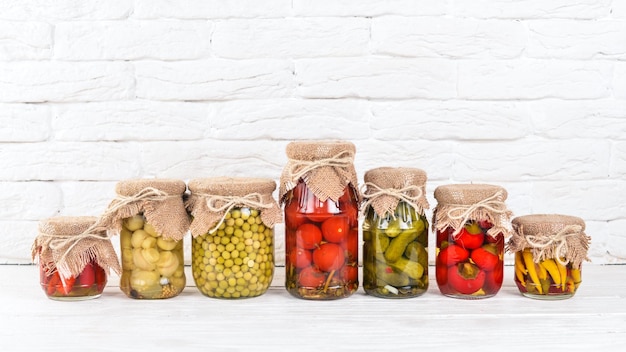 Foto alimentos em conserva em latas estoques de comida vista superior em um fundo de madeira copie o espaço