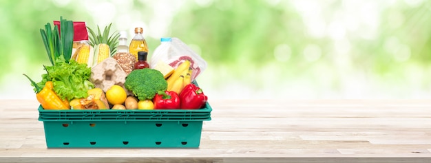 Alimentos frescos e compras em caixa de bandeja no fundo da bandeira de mesa de madeira