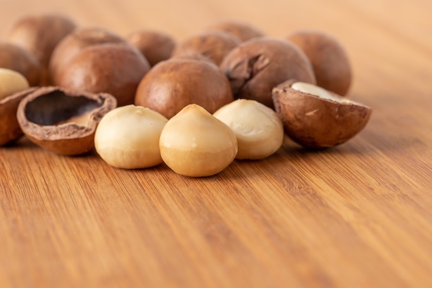 Alimentos de nutrición saludable de nueces de macadamia en mesa de madera