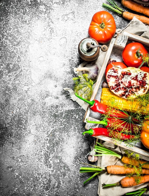 Alimentos orgánicos. Cosecha fresca de verduras y frutas sobre una mesa rústica.