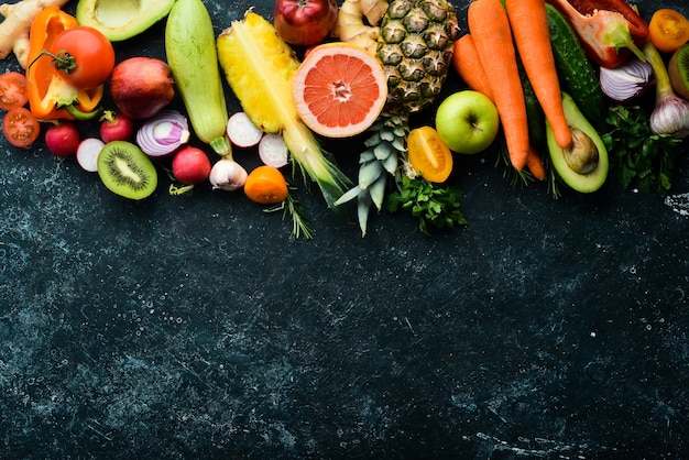 Alimentos orgânicos Legumes frescos e frutas em um fundo escuro