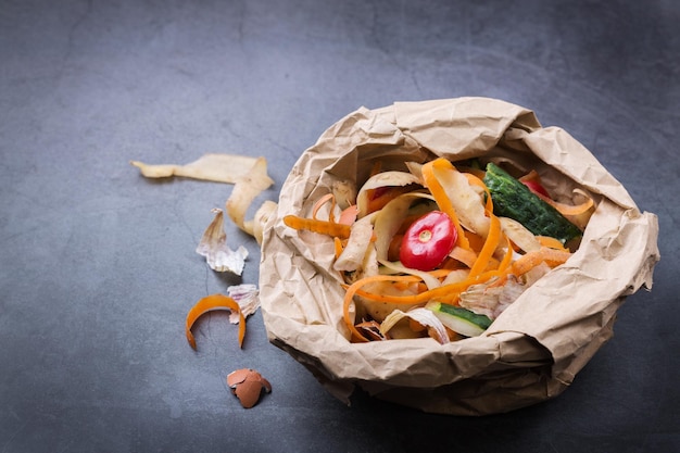 Alimentos orgánicos pelados, frutas y verduras para reciclar y convertir en abono en una mesa. Cero desperdicio, ecológico, sin plástico, reciclado, reutilizable, concepto sostenible. Clasificación de basura, restos de cocina.