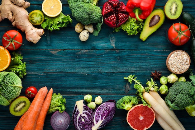 Alimentos orgánicos saludables sobre un fondo de madera azul Verduras y frutas Vista superior Espacio de copia libre