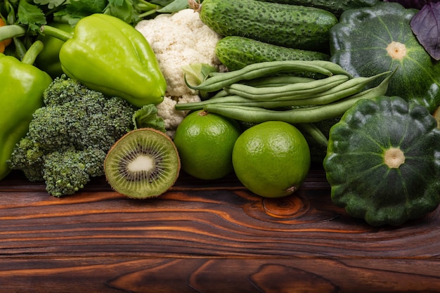 Alimentos orgânicos saudáveis vegetais verdes e ervas em fundo de madeira