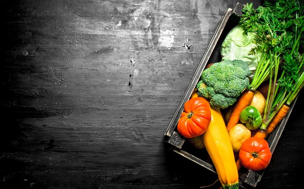 Alimentos orgánicos. Verduras frescas en una caja vieja. En la pizarra negra.