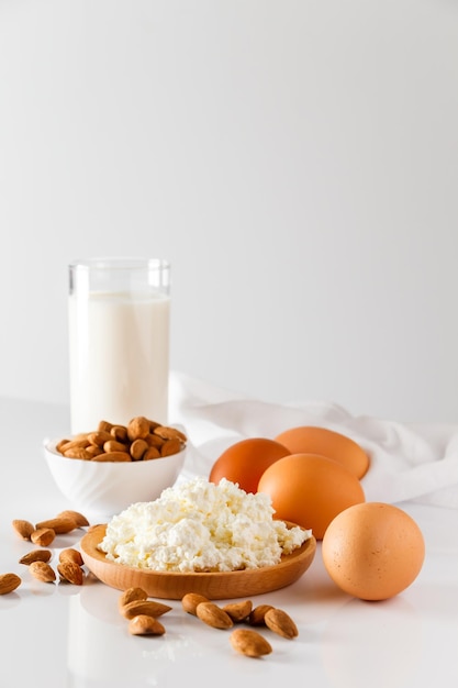 Alimentos proteicos em um fundo branco ovos de queijo cottage nozes Um conjunto de alimentos saudáveis para uma dieta equilibrada