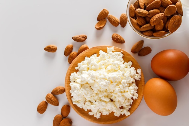 Alimentos proteicos em um fundo branco ovos de queijo cottage nozes um conjunto de alimentos saudáveis para uma dieta equilibrada