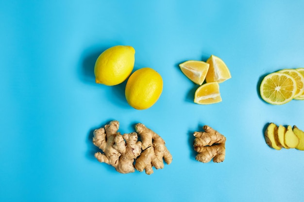 Alimentos que aumentan la inmunidad jengibre y limón sobre fondo azul.