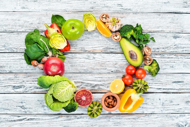 Alimentos que contienen fibra natural: aguacate, kiwi, manzana, tomate, espinaca, pimentón, naranja, limón. Vista superior. Espacio libre para su texto. Sobre un fondo blanco.