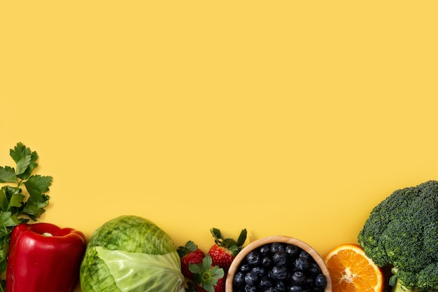 Alimentos saludables, frutas y verduras aisladas sobre fondo amarillo