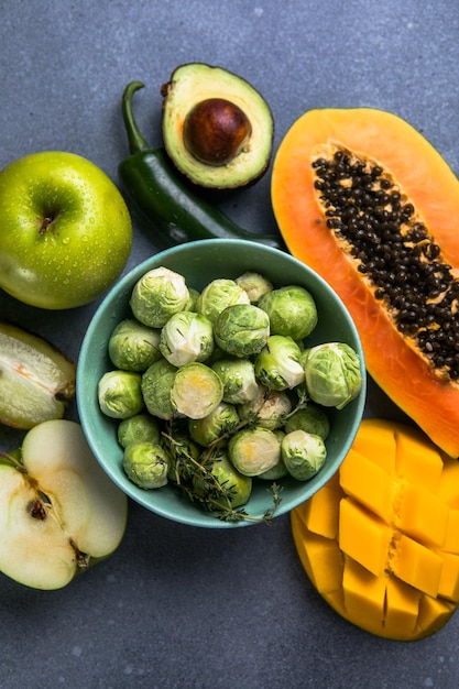 Alimentos saludables selección de alimentos limpios frutas verduras superalimentos vegetales de hoja sobre un fondo de hormigón gris