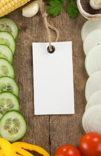 Alimentos vegetais e etiqueta de preço sobre textura de madeira