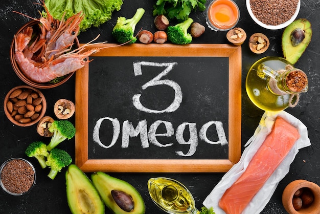 Alimentos con vitamina natural Omega 3 Alimentos saludables pescado camarones brócoli lino nueces huevo perejil Vista superior Espacio libre para su texto Sobre un fondo negro