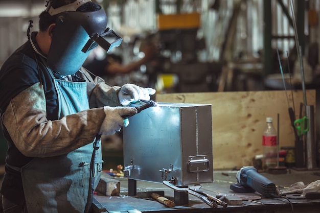 Aliminum Welding, Masked Arbeiter und Schutzhandschuhe Aliminum Welding in der Fabrik.