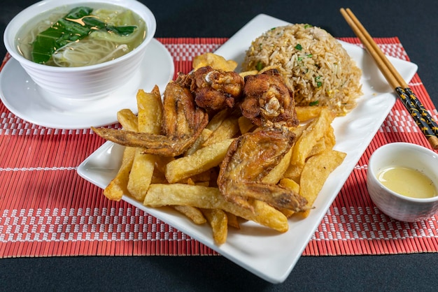 Alitas y papas fritas con arroz chaufa. Comida china peruana.