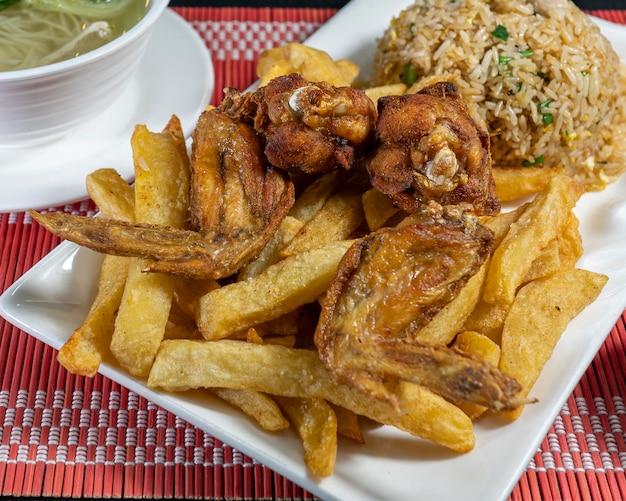 Alitas y papas fritas con arroz chaufa. Comida china peruana.