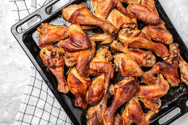 Alitas y patas de pollo al horno en trozos en una bandeja para hornear. Menú de restaurante, dieta, receta de libro de cocina.