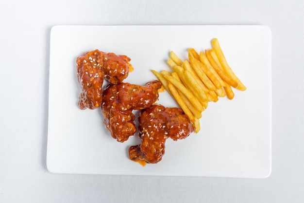 Alitas picantes de búfalo y papas fritas con salsa blanca en plato blanco aislado fondo blanco Vistas superiores