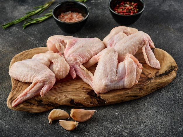 Alitas de pollo crudas Carne de ave con especias sal y pimienta sobre fondo gris