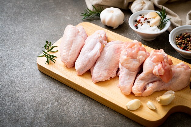 Foto alitas de pollo crudas frescas sobre tabla de madera