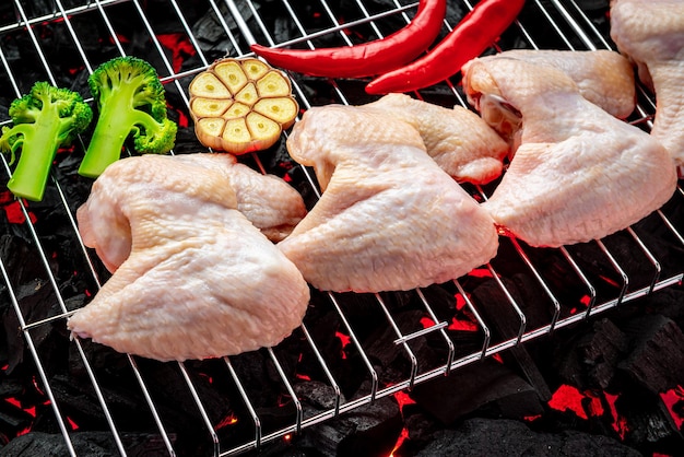 Alitas de pollo crudas a la parrilla brasas de la parrilla