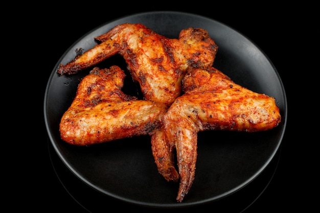 Alitas de pollo fritas en un plato negro Alitas de pollo a la barbacoa