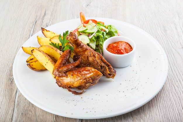 alitas de pollo frito con ensalada de papas fritas y salsa picante