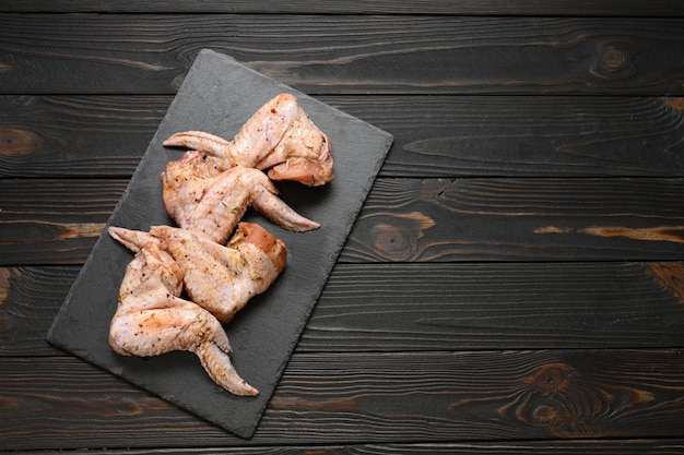 Alitas de pollo marinadas sobre un fondo rústico de madera