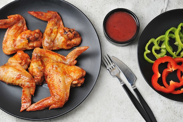 Alitas de pollo marinado frito en un plato negro