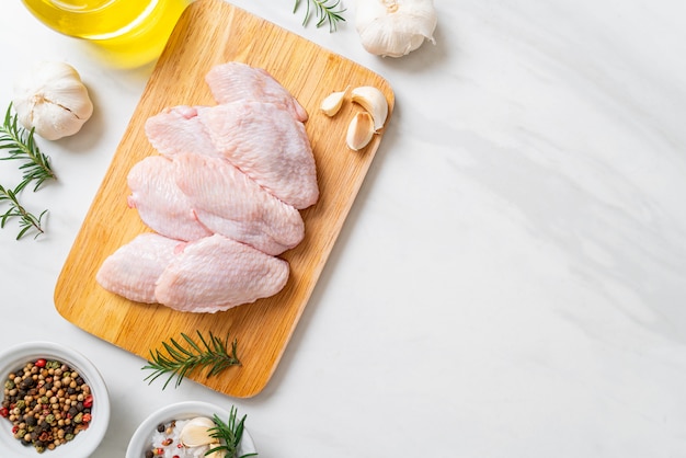 Alitas de pollo medio crudas frescas sobre tabla de madera