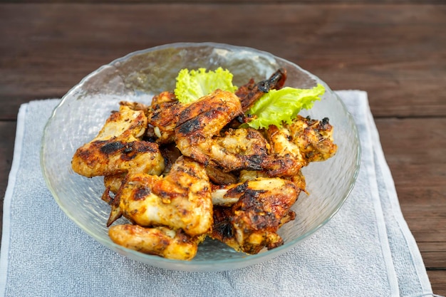 Alitas de pollo en un plato sobre una servilleta sobre una mesa de madera