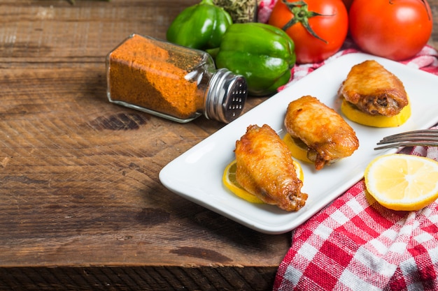 Foto alitas de pollo con verduras de fondo