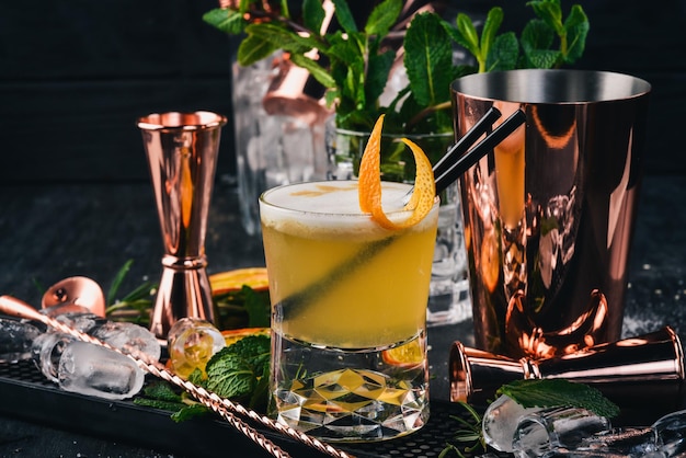 Alkohol-Cocktail-Whisky Sauer auf einem schwarzen hölzernen Hintergrund