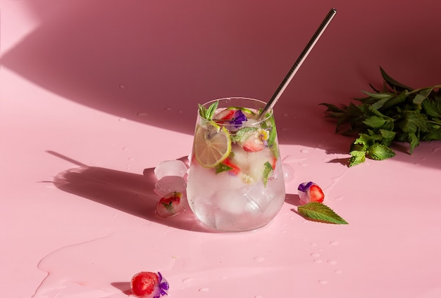 Alkoholfreier Cocktail mit gefrorenen Erdbeeren, Minze und Blumen.