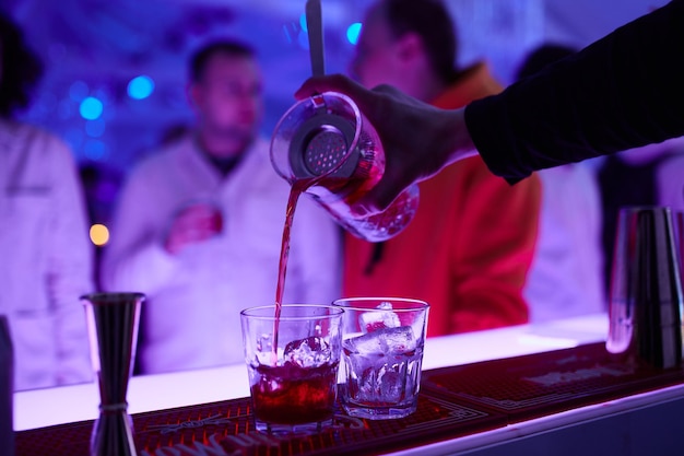 Alkoholische Getränke an der Bar. Die Hände des Barkeepers bei der Zubereitung von Getränken.