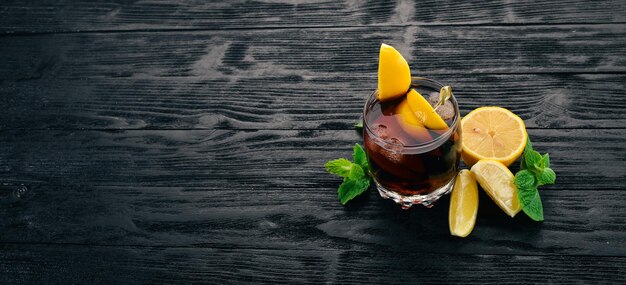 Alkoholischer Cocktail aus Whiskey-Zitrone und Minze RumCola Brandy auf schwarzem Holzhintergrund Freier Platz für Text