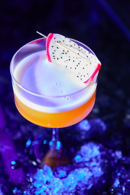 Alkoholischer Cocktail mit einer Scheibe Pitaya oder Pitahaya auf der Bartheke