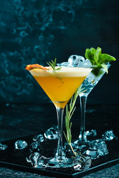 Alkoholischer Cocktail mit Sanddorn und Orange mit Likör in einem Glas auf schwarzem Steinhintergrund Menüleiste
