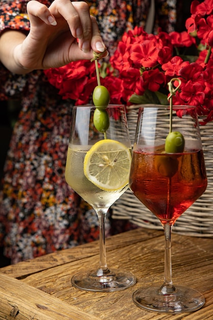 Alkoholischer Cocktail mit Zitrone und Olive auf einem Holztisch