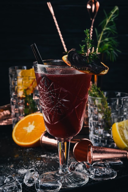 Alkoholischer Cocktail Rum-Pfirsichlikör-Kirschsaft auf schwarzem Holzhintergrund
