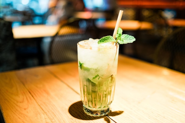 Alkoholischer Mojito-Cocktail mit Minze-Lime-Scheiben und Eis auf einer Bar