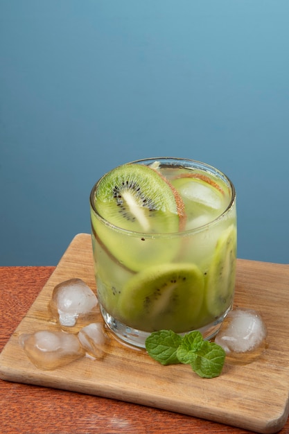 Alkoholisches Getränk Caipirinha basierend auf Kiwi-Cocktail auf einer blauen Wand