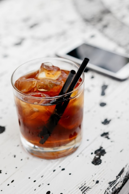 Alkoholismus, Alkoholabhängigkeit und Menschenkonzept - Nahaufnahme mit einem Glas Whisky und einem Smartphone auf dem Tisch