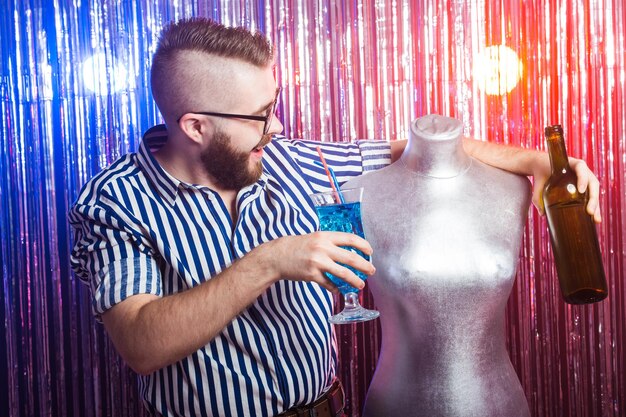 Foto alkoholismus, spaß und narrenkonzept - betrunkener verrückter kerl auf einer party in einem nachtclub.