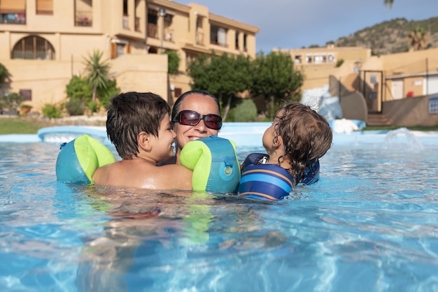 Alleinerziehende Familie beim Spielen im Schwimmbad Der Sommer hält Einzug auf der Nordhalbkugel