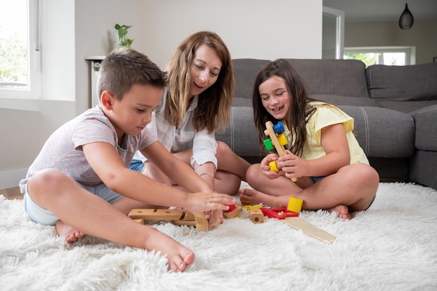 Foto alleinerziehende mutter, die zu hause mit ihren kindern spielt