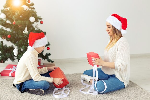 Alleinerziehende und Feiertagskonzept - Porträt von Mutter und Sohn, die Weihnachten zu Hause an Heiligabend feiern