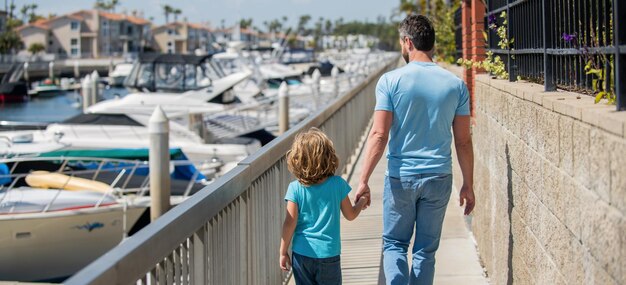 Alleinerziehender Vater, der ein kleines Kind außerhalb der Rückansicht der Zweisamkeit führt